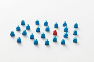 Photo of a Red Meeple Between Blue Meeples