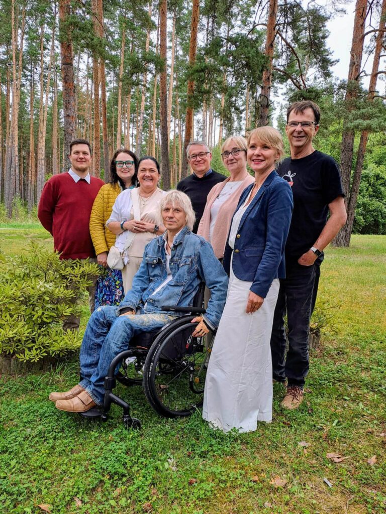 Eesti Puuetega Inimeste Koja juhatuse liikmed ühispildil, taustal männimets. Vasakult paremale: Mihkel Tõkke, Merike Värik, Ulvi Tammer-Jäätes, Hegert Mölder, Meelis Joost, Veronika Allas, Kaili Leino, Kaido Vaatemäe.